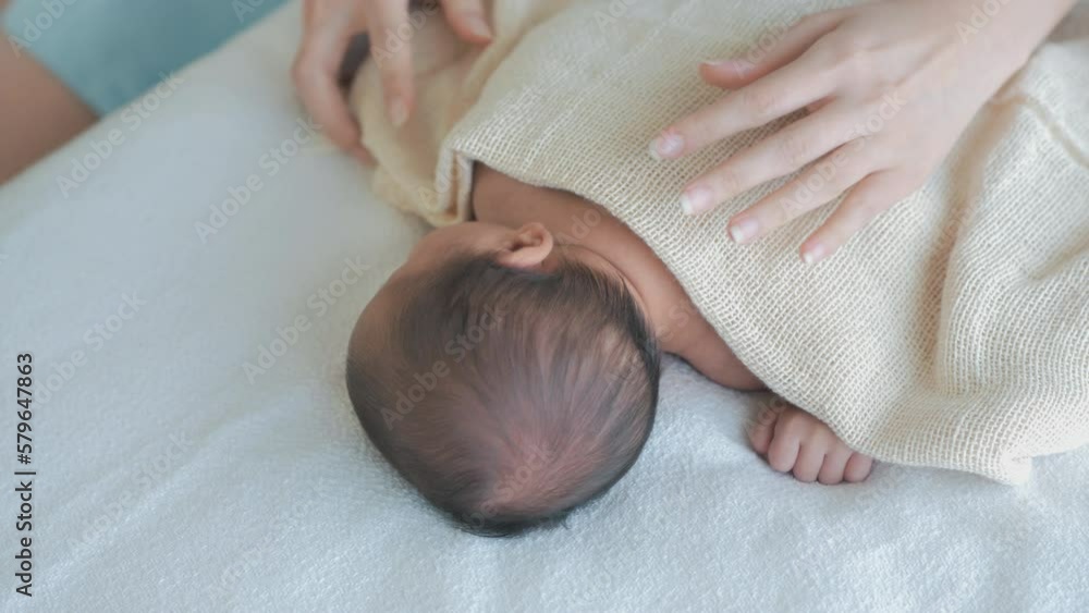 Mother puts on a blanket for her baby, Child Care Mother puts on a blanket for her baby, Child Care