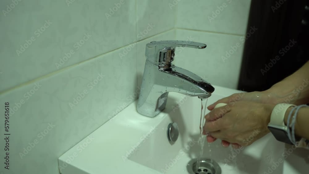 Body Care. A woman washes her hands with soap and water under the tap in the sink. Body Care. A woman washes her hands with soap and water under the tap in the sink.