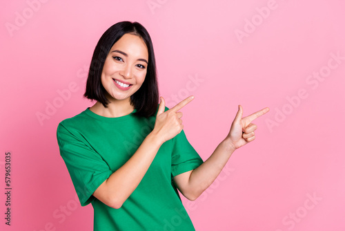 Portrait of cheerful lovely woman straight hairstyle wear oversize t-shirt directing at sale empty space isolated on pink color background