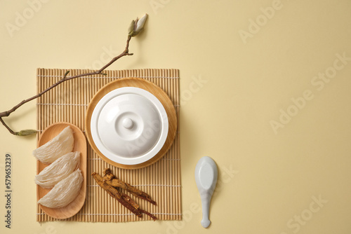 Canvas Print Top view of a white bowl decorated with a dish of edible bird’s nest, ginseng (Panax ginseng) and a branch