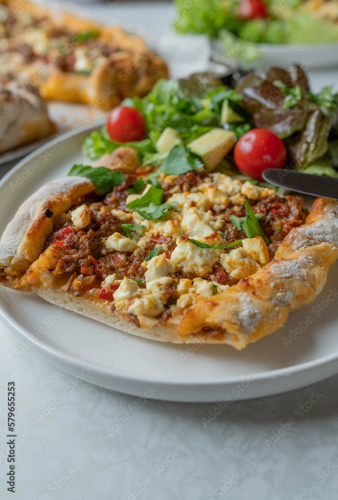 Turkish pide or flatbread with ground beef, vegetables and feta cheese