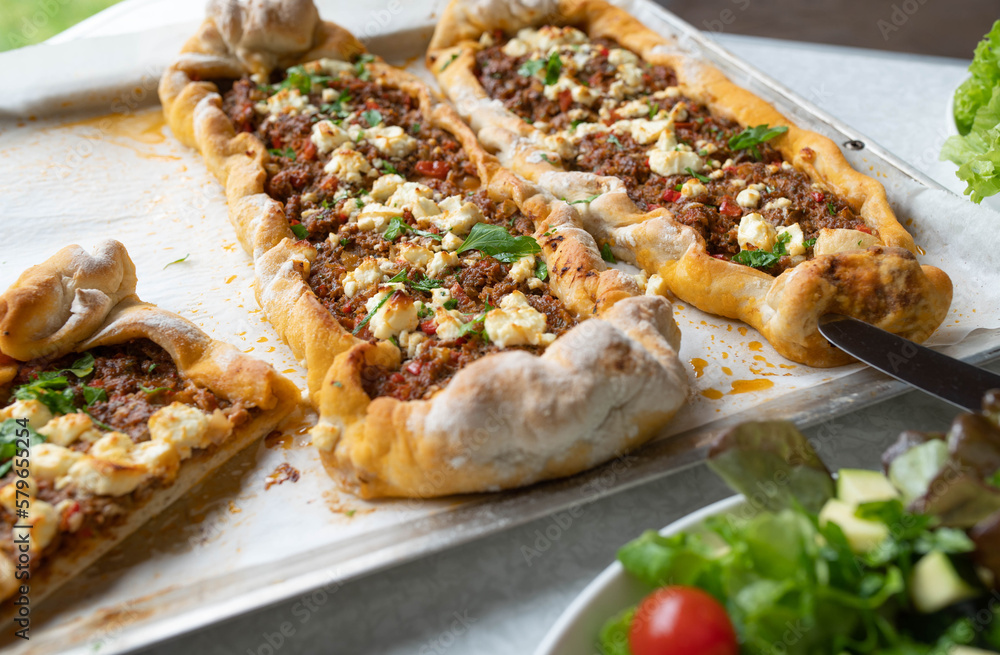 Homemade turkish pide with ground beef, vegetables and feta cheese