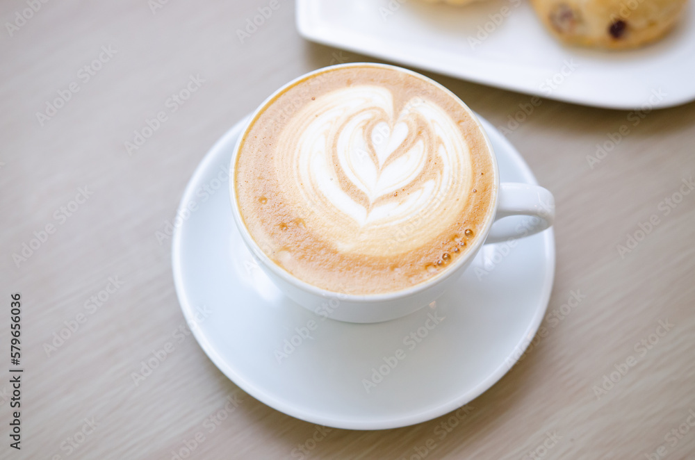 A wooden table with a fragrant cappuccino and baked bread A wooden table with a fragrant cappuccino and baked bread