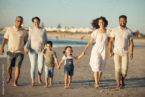 Family on beach with children smile while parents, kids grandparents holding hands on vacation by the ocean. Black family walking in sand by the sea, show love and bonding on holiday or reunion