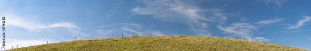 Panorama of pasture on hill in front of blue sky in bavaria