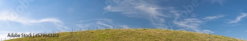 Panorama of pasture on hill in front of blue sky in bavaria