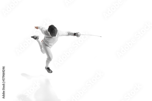 Full-length portrait of sportive man, professional fencer in fencing costume and protective helmet mask in motion isolated on white studio background.
