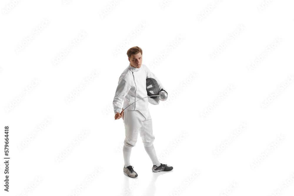 Young man, male fencer in fencing costume mask standing with sword over white studio background. Sport, motivation, professional skills Young man, male fencer in fencing costume mask standing with sword over white studio background. Sport, motivation, professional skills
