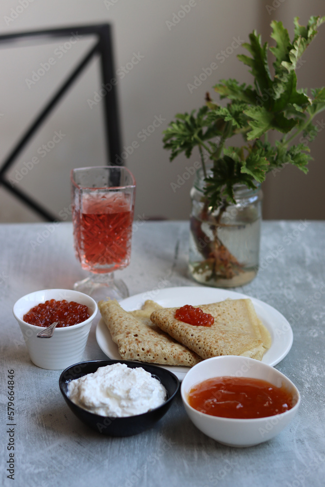 Tiny crepes on a plate. Crepes with salmon caviar. Savory food close up photo. Traditional French pancakes. Tiny crepes on a plate. Crepes with salmon caviar. Savory food close up photo. Traditional French pancakes.