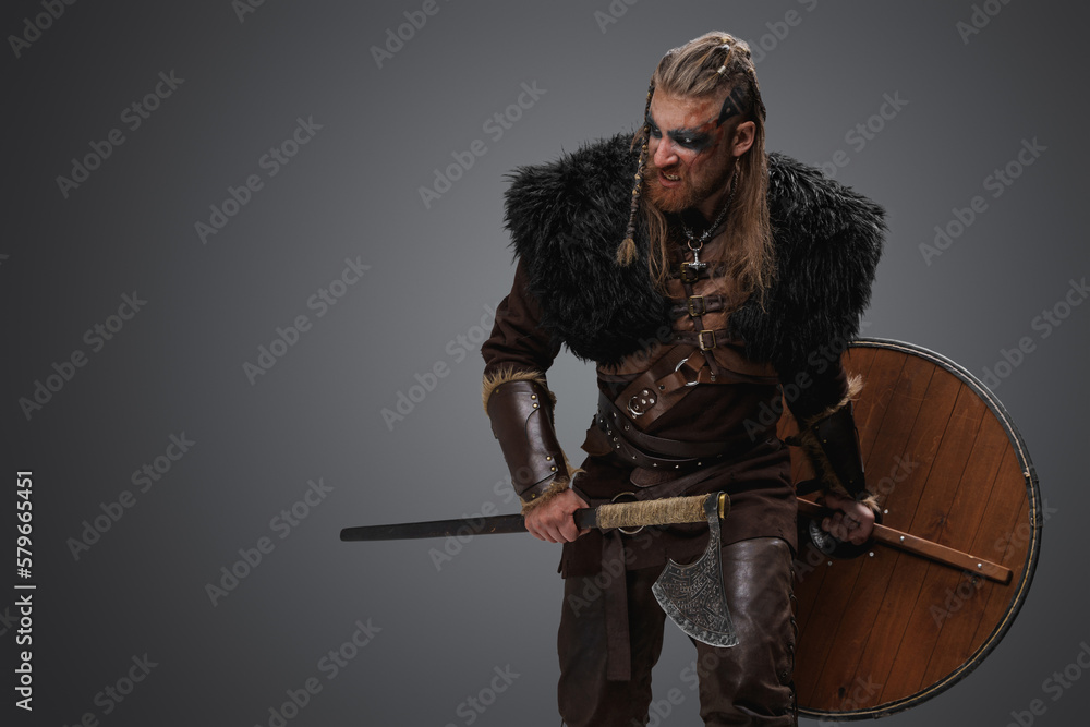 Portrait of violent barbarian from north with deerskin and armor against gray background. Portrait of violent barbarian from north with deerskin and armor against gray background.