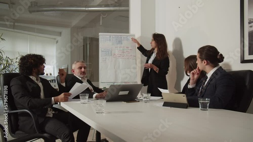 A young businesswoman explains to her partners the benefits of a new business model. A female entrepreneur makes a presentation during a meeting.