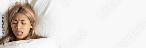 Fotografia Tired and stressed Asian woman with colored hair sleeping, having bad dream, nig
