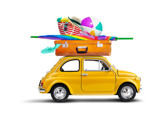 Retro yellow car with luggage and beach equipment on the roof. Summertime vacation road trip concept.