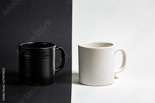 Black and white cups of coffee on abstract black and white background