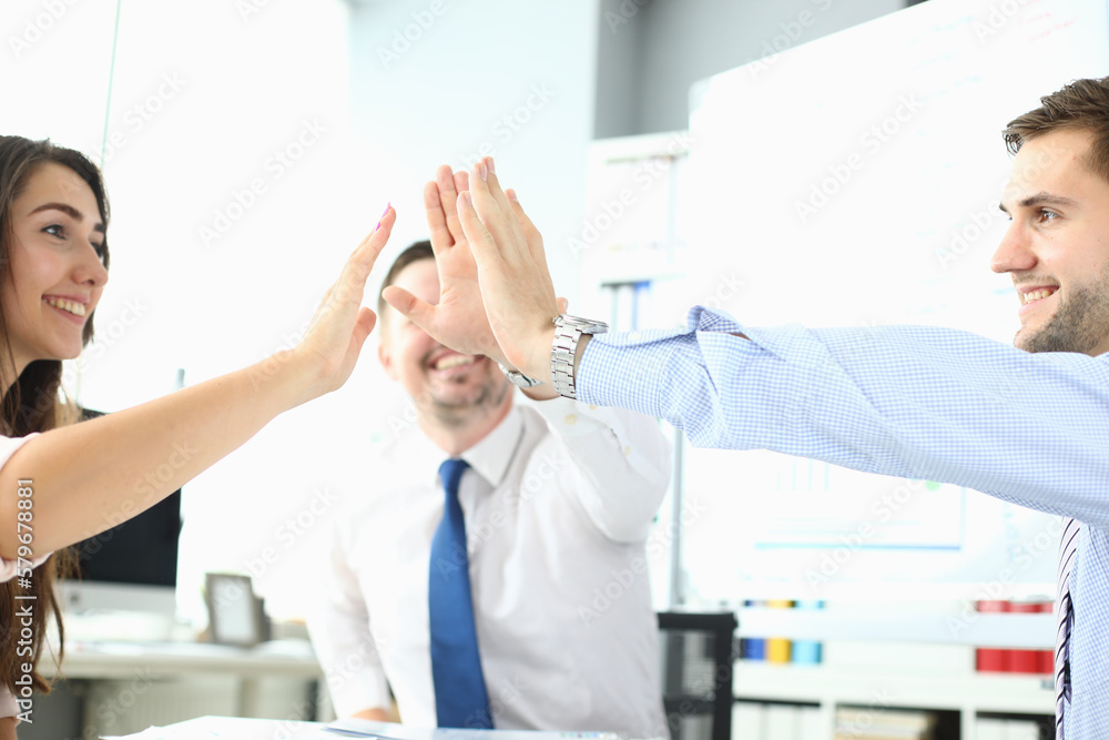 Happy business team high five in office Happy business team high five in office