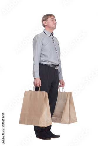 senior man with shopping bags reading the ad on a white screen .