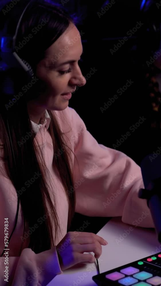 Side angle of young female podcaster and her guest. Vertical video Side angle of young female podcaster and her guest. Vertical video