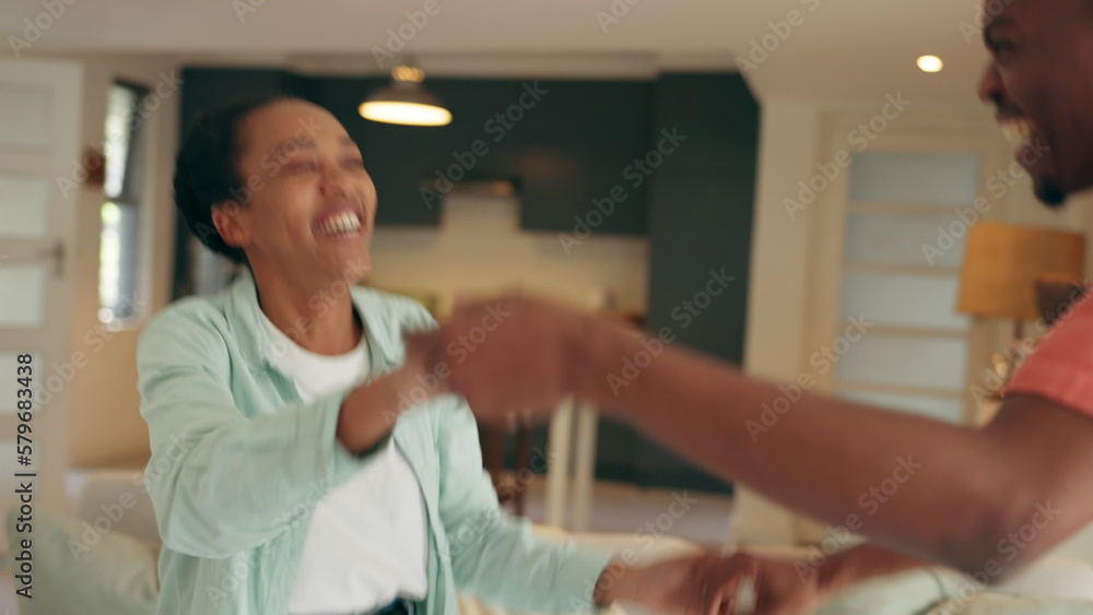 Happy young couple dance to music together at home, they joke as they smile and laugh in love at room new house. A black couple enjoy a playful moment in their relationship, dancing playfully and hug