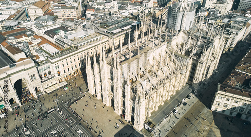 Aerial view of Piazza Duomo in front of the gothic cathedral in the center. Drone view of the gallery and rooftops during the day. Milan, Italy. High quality photo