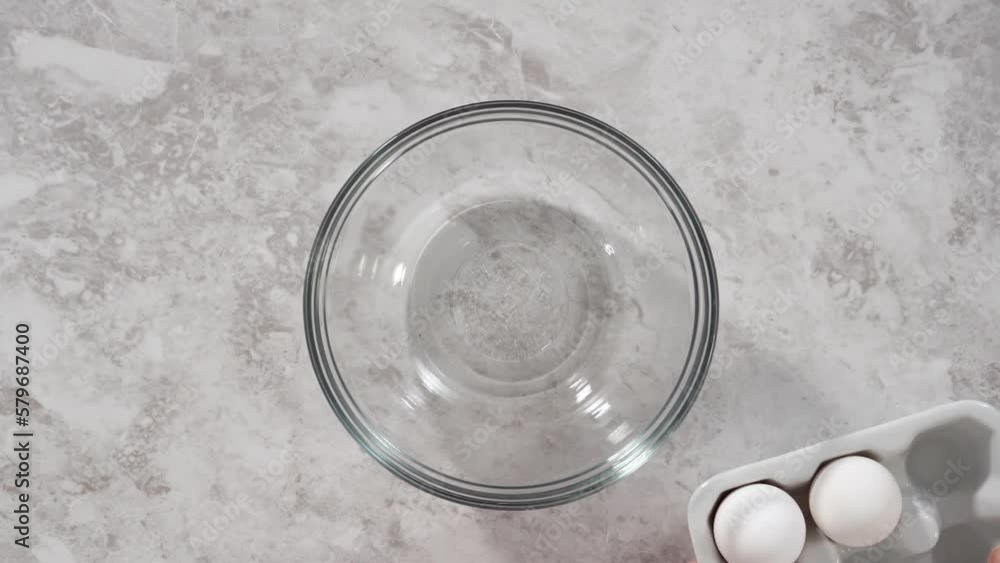 Flat lay. Mixing ingredients in a glass mixing bowl to bake funfettti bundt cake. Flat lay. Mixing ingredients in a glass mixing bowl to bake funfettti bundt cake.