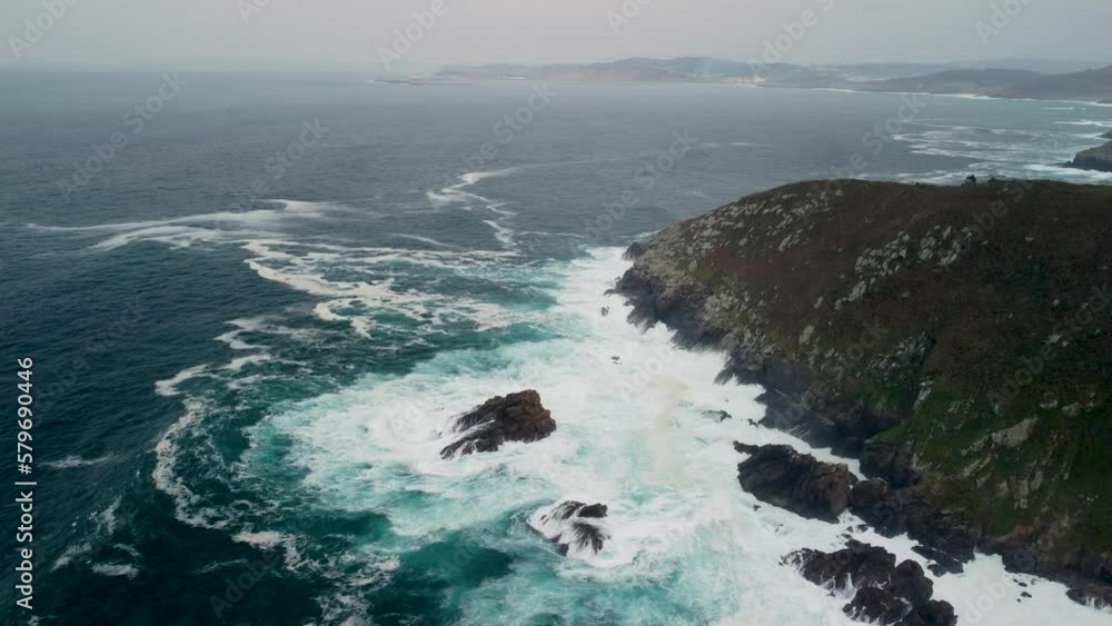 Foamy Tidal Waves Crashes Over Outcrops And Rocky Cliffs Near Caion Beach In Coruna, Spain. Aerial Wide Shot Foamy Tidal Waves Crashes Over Outcrops And Rocky Cliffs Near Caion Beach In Coruna, Spain. Aerial Wide Shot