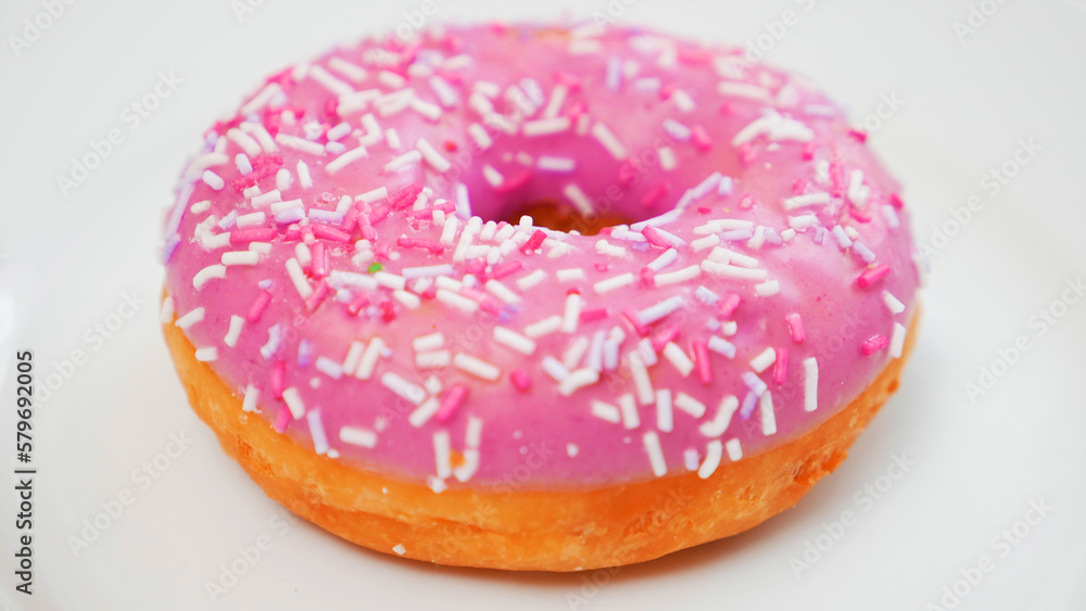Donut with sprinkles on a white plate Donut with sprinkles on a white plate