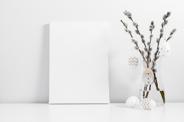 Easter holiday composition. White linen blank canvas mockup, vase with willow plant branches, easter eggs, bunny on white table. Front view.