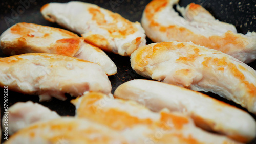 chicken meat is fried in a frying pan