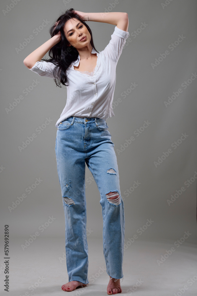 a beautiful brunette woman in a casual outfit in the studio a beautiful brunette woman in a casual outfit in the studio