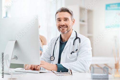 Research is what allows me decide how to best treat patients. Portrait of a mature doctor working on a computer in a medical office.