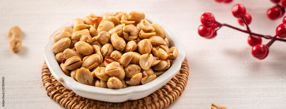 Spicy flavored peanut kernel in a bowl on white table background. Spicy flavored peanut kernel in a bowl on white table background.