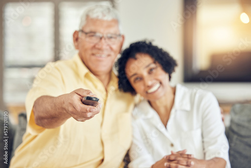 Portrait of senior couple watching tv on sofa with comedy show, film or movies at home together with love and hug. Biracial people or woman with elderly partner watch television and relaxing on couch