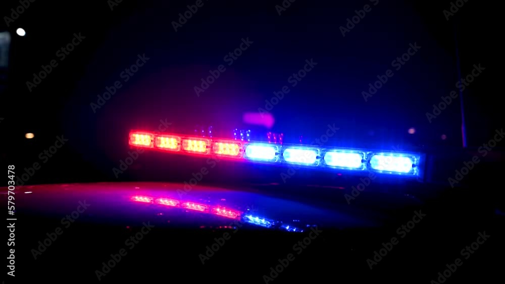 Police emergency lights flashing at a crime scene at night. Flashlights