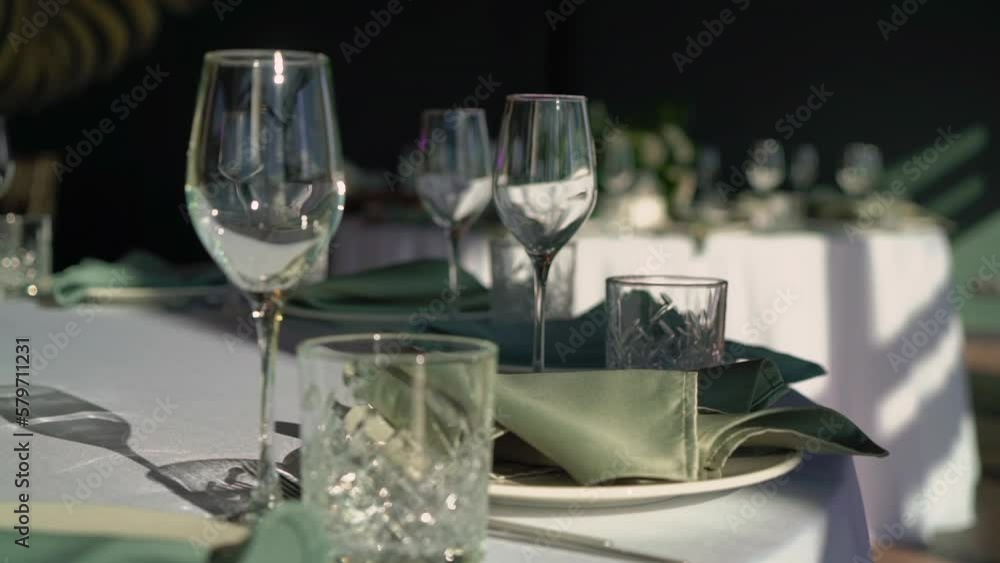 Served tables for a holiday in a restaurant. Glasses, plates, cutlery, napkins. Wedding decor, celebration dinner or party, reception indoors. No food. Served tables for a holiday in a restaurant. Glasses, plates, cutlery, napkins. Wedding decor, celebration dinner or party, reception indoors. No food.
