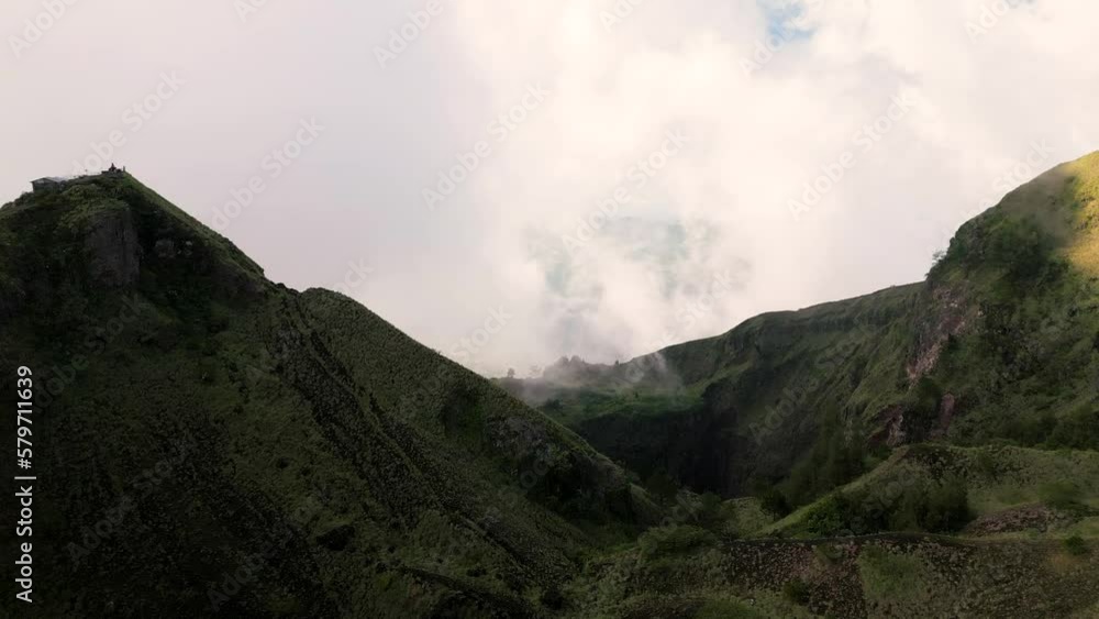 Sunrise at the top of Batur volcano. People walk along the caldera. Shooting from a drone. Bali, Indonesia