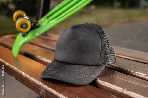 Trucker cap, snapback, all black, black mesh. In location on playground. Mock-up for branding photo