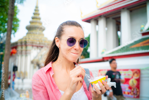 Photography Woman enjoy eat street food ice cream travel in buddha temple