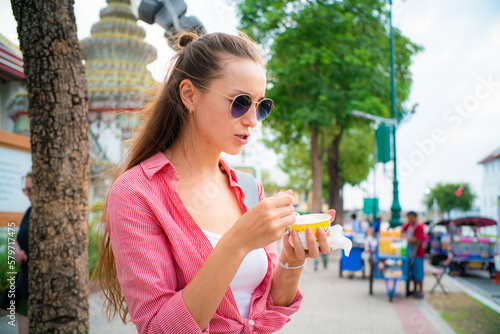 Woman enjoy eat street food ice cream travel in buddha temple