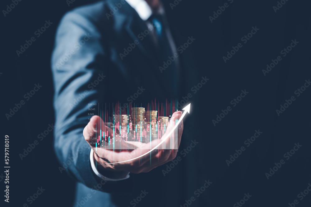 Naklejka premium investment saving strategy and finance concept, businessman holding virtual trading graph and blurred coins on hand, stock market, profits and business growth.