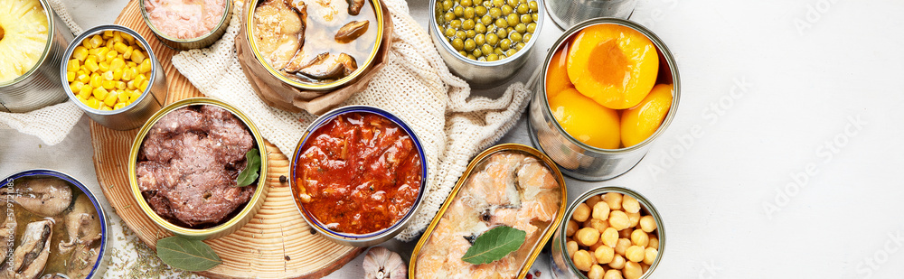 Canned vegetables, beans, fish and fruits in tin cans on a white background. Food stocks.