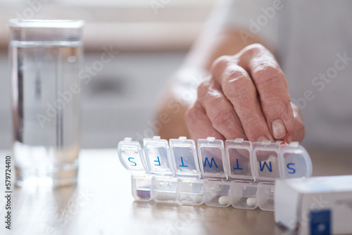 Too much poison come undone. Cropped shot of an unrecognizable elderly man arranging his medication at the table at home.