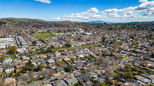 Aerial photos over a community in Vallejo, California with houses, streets, cars and parks on a sunny day in March. photo