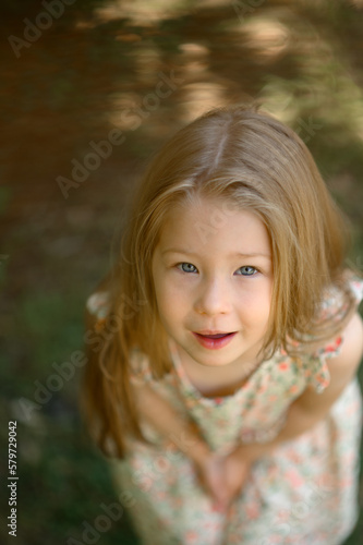 Little girl 3 years old in a summer sundress in the park. Summer time.