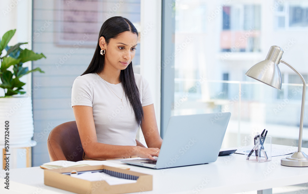 Focused and ready to tackle this day. Shot of a young businesswoman using her laptop at work. Focused and ready to tackle this day. Shot of a young businesswoman using her laptop at work.