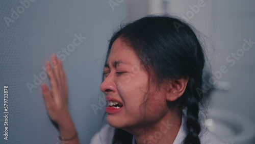 a high school teenager crying in the bathroom after getting violence from his friend