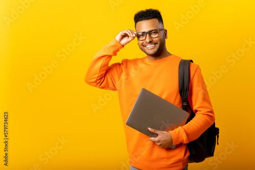Fotografiet Smart inteligente indian male employee or freelancer man holding laptop and look