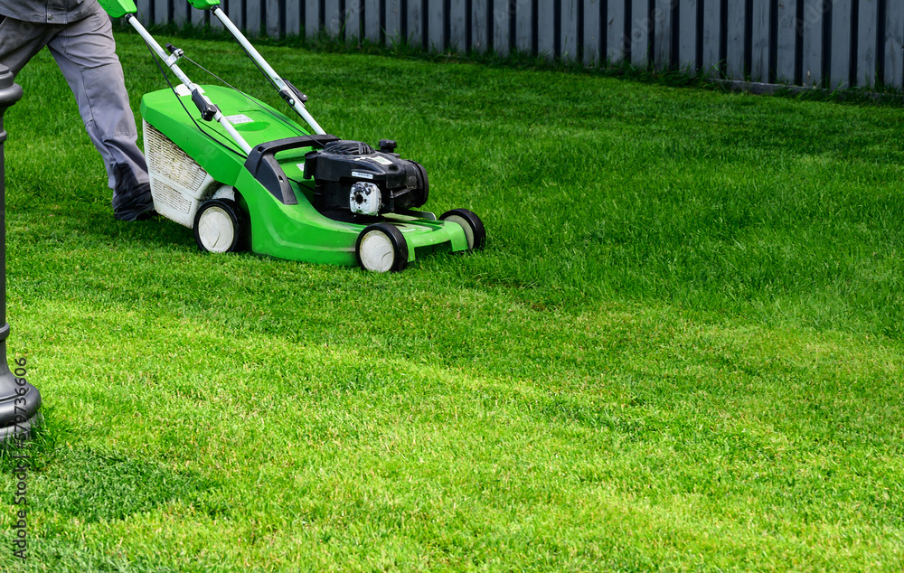 Lawn mover on green grass in modern garden. Machine for cutting lawns. Lawn mover on green grass in modern garden. Machine for cutting lawns.