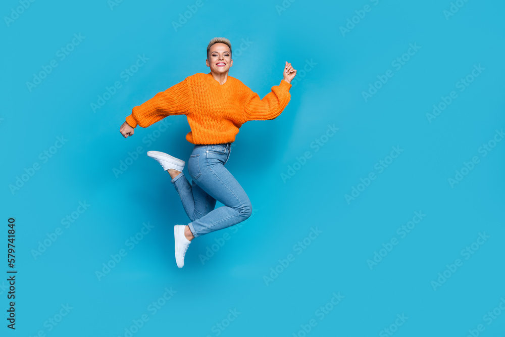 Full length photo of shiny pretty dressed knitted pullover jumping high running fast empty space isolated blue color background