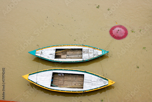 Barcas de colores amarradas en el rio Ganges en la india con el agua marron y muy turbia photo