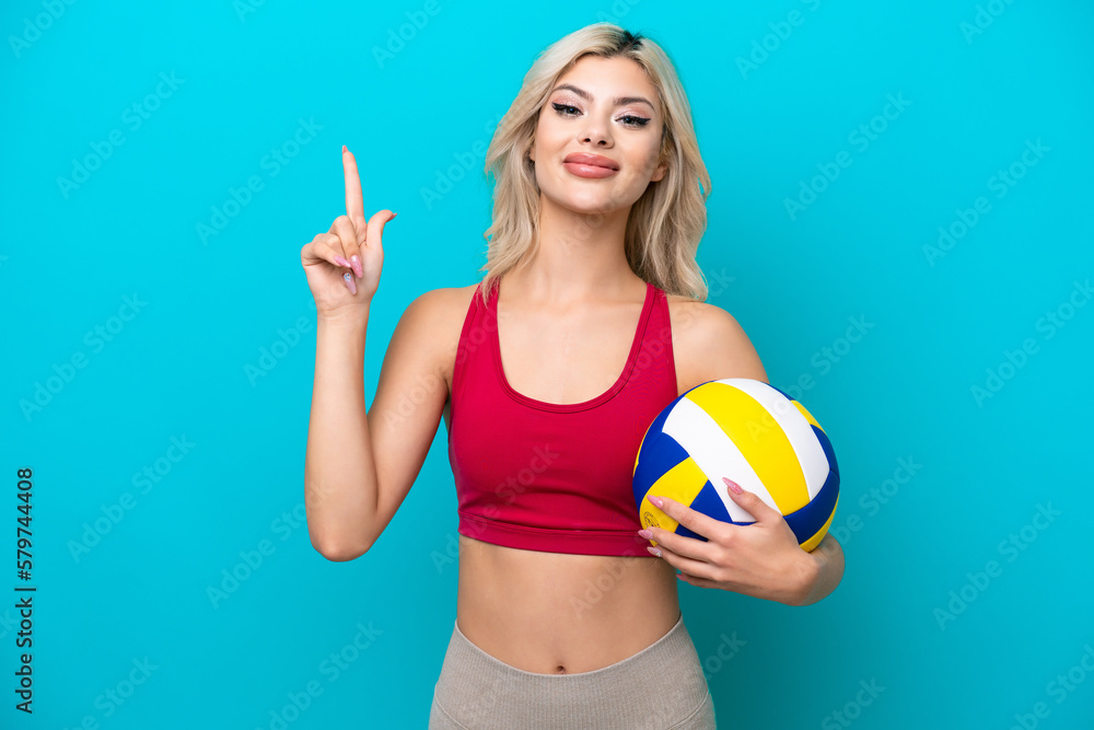Young Russian woman playing volleyball isolated on blue background showing and lifting a finger in sign of the best